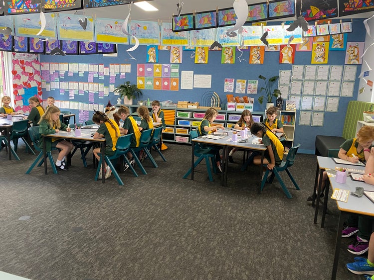 year 1 and 2 students learning at their desks in the classroom