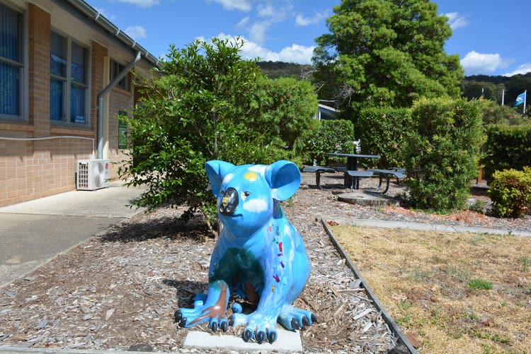 a blue koala sculpture in the garden