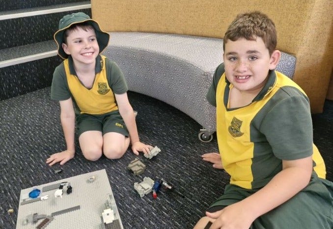 2 boys playing board games in the library