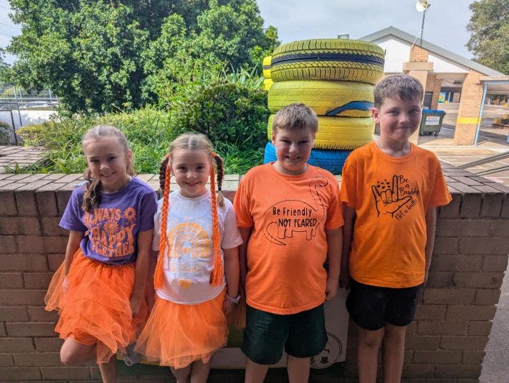 4 students wearing orange clothes on harmony day