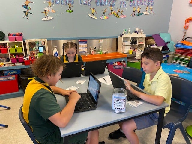 2 boys and a girl working on laptop computers