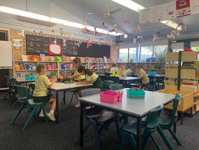 children working at desks in the library