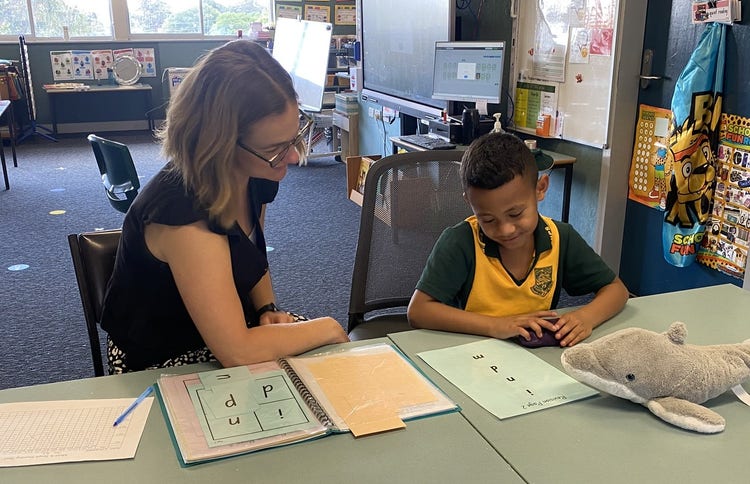 A teaching working individually with a kindergarten student